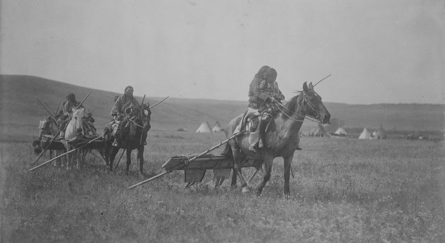 Edward S. Curtis, Moving camp, c. November 19, 1908, photographic print, Atsina on horses with travois behind them, tipis in background, Montana (Library of Congress) http://www.loc.gov/pictures/item/2002722337/
