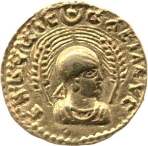 Gold coin, c. 270-300 C.E., gold, Aksumite, modern Ethiopia © Trustees of the British Museum. Obverse showing head and shoulders bust of King Endubis facing right, wearing headcloth with rays at forehead and triangular ribbon behind, framed by two wheat-stalks. Disc and crescent at top.