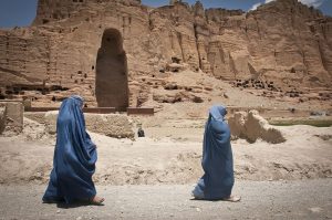 Two women walk past the site of the Buddhas of Bamiyan, June, 2012 (photo: Sgt. Ken Scar, public domain)
