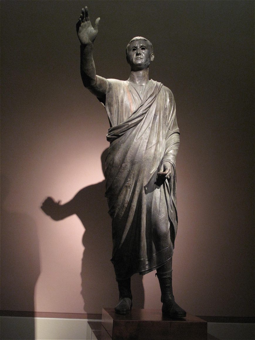 Aule Metele (Arringatore), from Cortona, Italy, early 1st century B.C.E., bronze, 67 inches high (Museo Archeologico Nazionale, Florence), (image w/shadow eliminated): corneliagraco, CC BY 2.0)