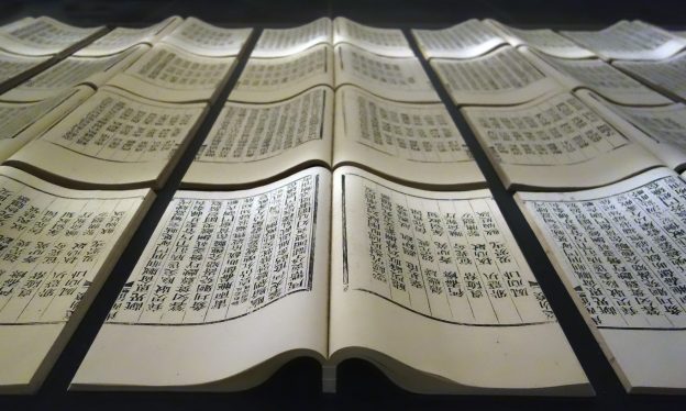 Xu Bing, Book from the Sky, c. 1987-91, hand-printed books and ceiling and wall scrolls printed from wood letterpress type; ink on paper, each book, open: 18 1/8 × 20 inches / 46 × 51 cm; each of three ceiling scrolls 38 inches × c. 114 feet 9-7/8 inches / 96.5 × 3500 cm; each wall scroll 9 feet 2-1/4 inches × 39-3/8 inches / 280 × 100 cm (installation at The Metropolitan Museum of Art, 2014), collection of the artist, © Xu Bing