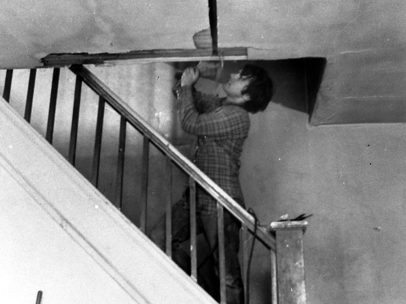 Gordon Matta-Clark in process of cutting the roof in Splitting, 1974