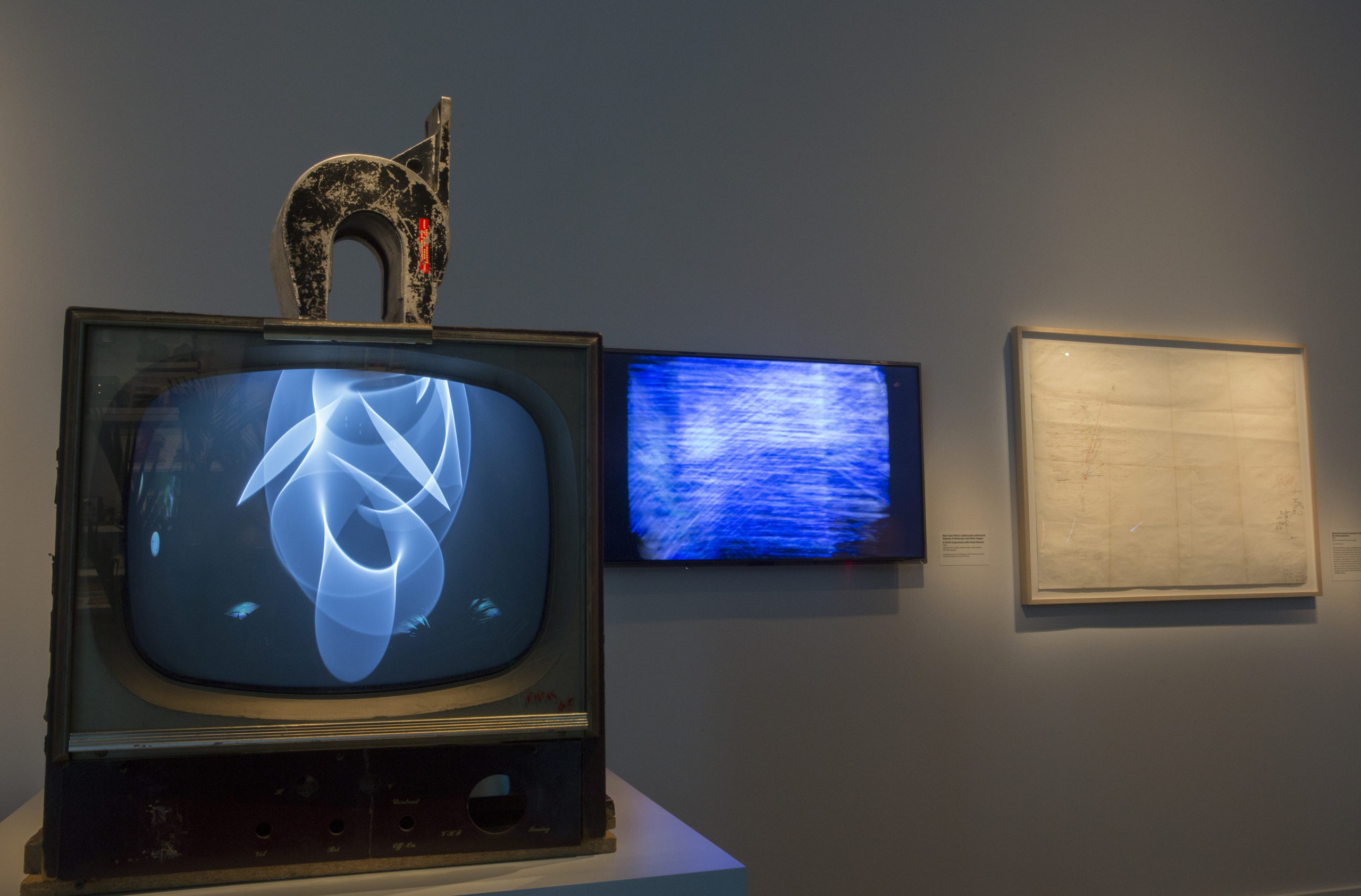 Left: Nam June Paik, Magnet TV, 1965, 17-inch television set and magnet; black and white, silent, 28 3/4 x 19 1/4 x 24 1/2 inches (Whitney Museum of American Art); Center: Nam June Paik in collaboration with David Atwood, Fred Barzyk, and Olivia Tappan, 9/23/69: Experiment with David Atwood, 1969, single-channel video; color, sound (Smithsonian American Art Museum); Right: Nam June Paik, Electronic Schematic Drawing for Paik/Abe Video Synthesizer, 1969, pencil, colored pencil and ink on paper, 30 3/4 x 43 inches (photo: Smithsonian American Art Museum, CC BY-NC-ND 2.0)