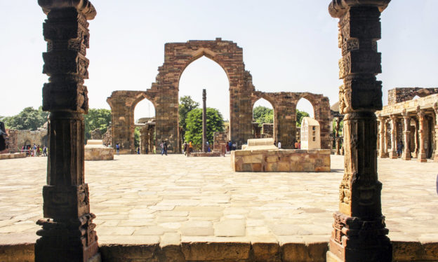The courtyard of the Quwwat-al-Islam mosque, c. 1192, Qutb archaeological complex, Delhi (photo: Indrajit Das, CC BY-SA 4.0). In the foreground are pillars of the colonnaded walkway and in the background is the c. 4th – 5th century iron pillar and the 12th century screen and prayer hall.