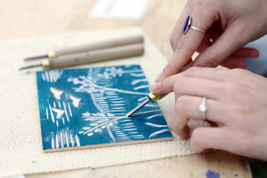 A contemporary artist uses a handheld gouger to cut a woodcut design into Japanese plywood. The design has been sketched in chalk on a painted face of the plywood (photo: Zephyris, CC BY-SA 3.0)