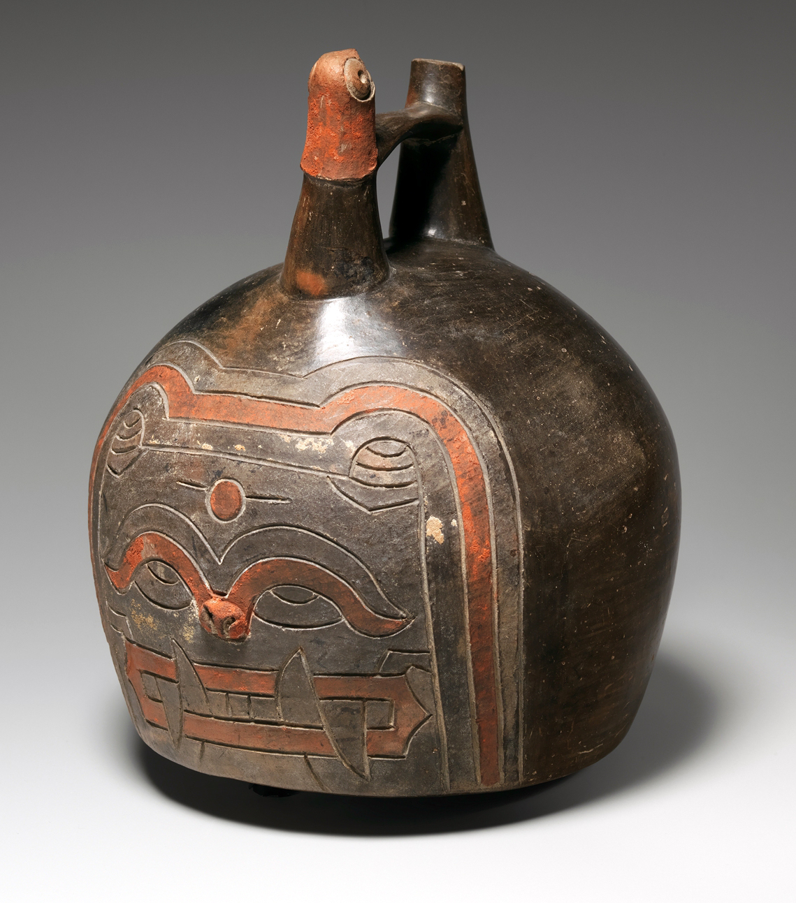Feline face bottle, Paracas, 4th–3rd century B.C.E., ceramic and post-fired paint, 17.8 x 14.3 x 13.7 cm, from the Ica Valley, Peru (The Metropolitan Museum of Art)