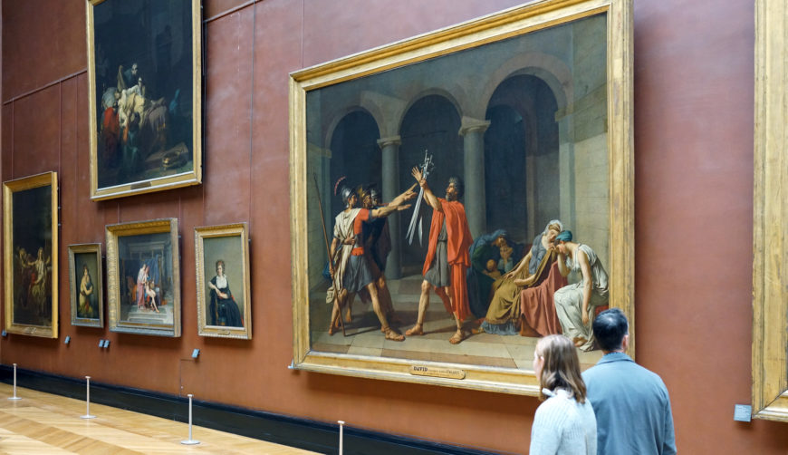 Viewers in front of Jacques-Louis David, Oath of the Horatii, 1784, oil on canvas, 3.3 x 4.25m, painted in Rome, exhibited at the salon of 1785 (Musée du Louvre)