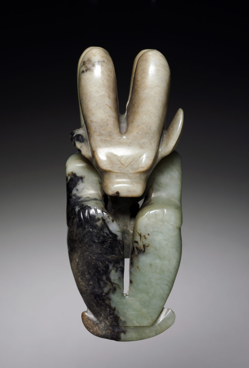 Amulet in the Form of a Seated Figure with Bovine Head 牛首玉人, c. 4700–2920 B.C.E. (Neolithic period), probably Hongshan culture, jade (nephrite), northeast China, 13.2 cm (The Cleveland Museum of Art)