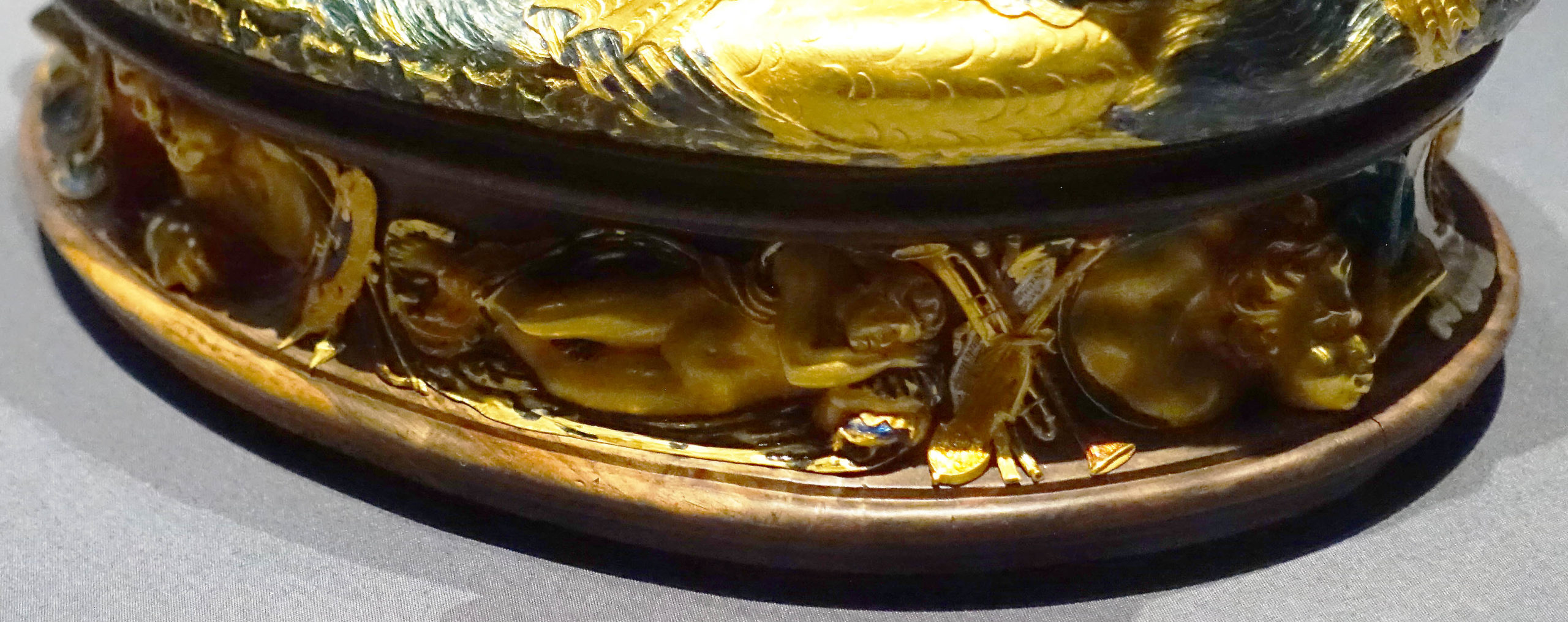 One of the four winds with puffed out cheeks on the base below the horses. Instruments are visible to the left of the personification of one of the winds. Benvenuto Cellini, Salt cellar, 1540-43, gold, enamel, ebony, and ivory, 28.5 x 21.5 x 26.3 cm (Kunsthistorisches Museum, Vienna; photo: Steven Zucker, CC BY-NC-SA 2.0)