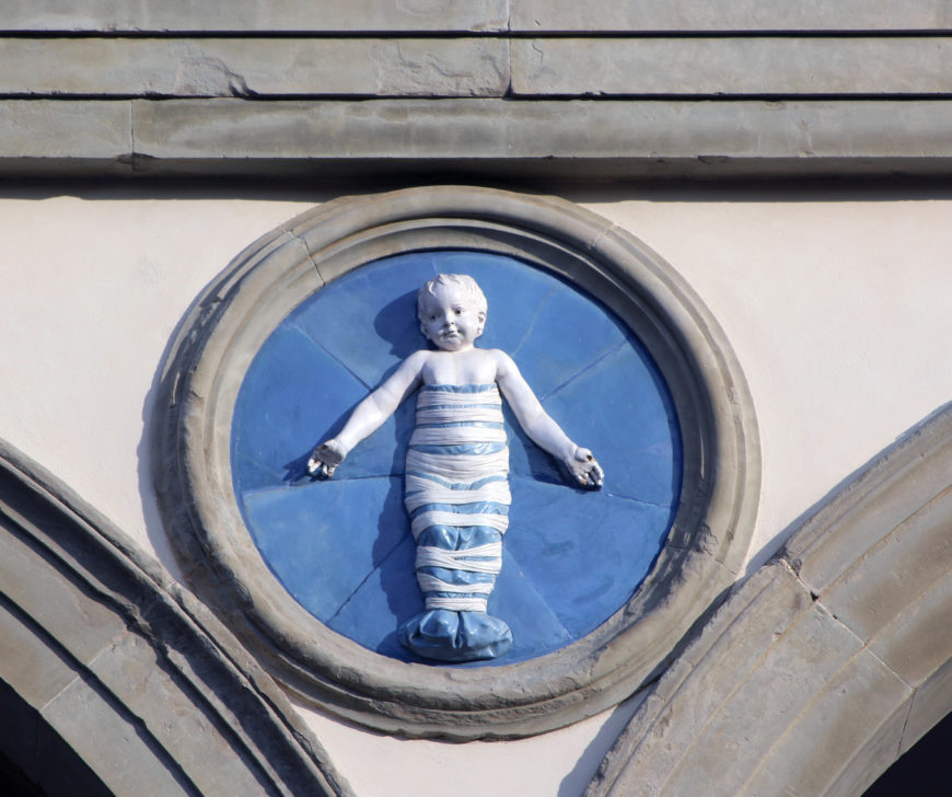 Andrea della Robbia, Infant in Swaddling Clothes, 1487, glazed terracotta, diameter about 100 cm. Ospedale degli Innocenti, Florence. Image: author.