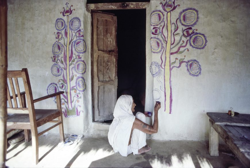 A Brahmin woman in Jitwarpur, India, painting lotus leaves at the entry of her home, 1988. Photo courtesy of Claire Burkert.