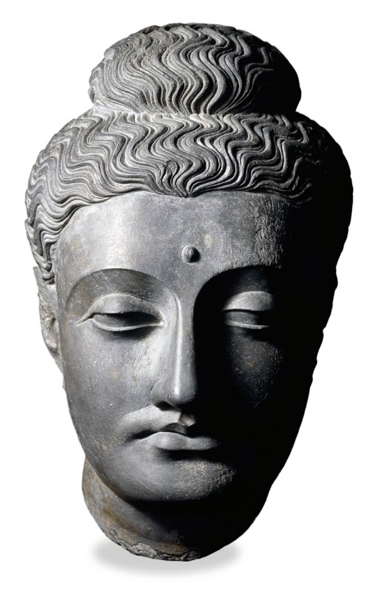 Title: Head of the Buddha, c. 100–300 C.E., Kushan dynasty, dark grey schist, made in Gandhara, Pakistan, 38.7 x 23.50 (© Trustees of the British Museum)