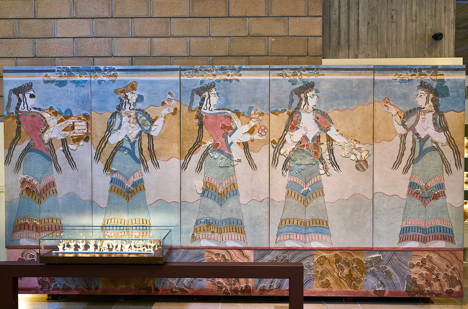 Reconstruction of a wall-painting from Thebes. Five women dressed in elaborate, brightly-coloured ruffled skirts, open-fronted tops, and headdresses, walk in a procession, holding offerings such as flowers. Photo: George E. Koronaios, CC0, via Wikimedia CommonsReconstruction of a wall-painting from Thebes. Five women dressed in elaborate, brightly-coloured ruffled skirts, open-fronted tops, and headdresses, walk in a procession, holding offerings such as flowers. Photo: George E. Koronaios, CC0, via Wikimedia Commons