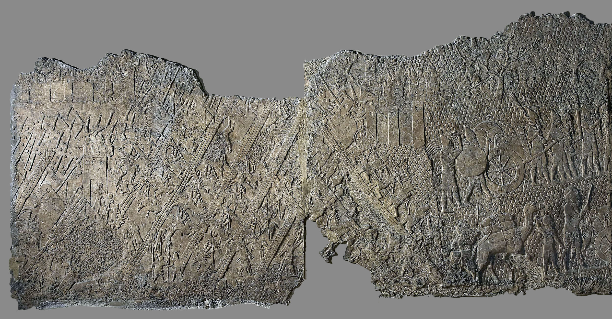 Part of a series which decorated the walls of a room in the palace of King Sennacherib (reigned 704-681 B.C.E.). The Assyrian soldiers continue the attack on Lachish. They carry away a throne, a chariot and other goods from the palace of the governor of the city. In front and below them some of the people of Lachish, carrying what goods they can salvage, move through a rocky landscape studded with vines, fig and perhaps olive trees. Sennacherib records that as a result of the whole campaign he deported 200,150 people. This was standard Assyrian policy, and was adopted by the Babylonians, the next ruling empire. The Siege and Capture of the City of Lachish in 701 B.C.E., South-West Palace of Sennacherib, Nineveh, northern Iraq, Neo-Assyrian, c. 700-681 B.C.E., alabaster, 182.880 x 193.040 cm (The British Museum)
