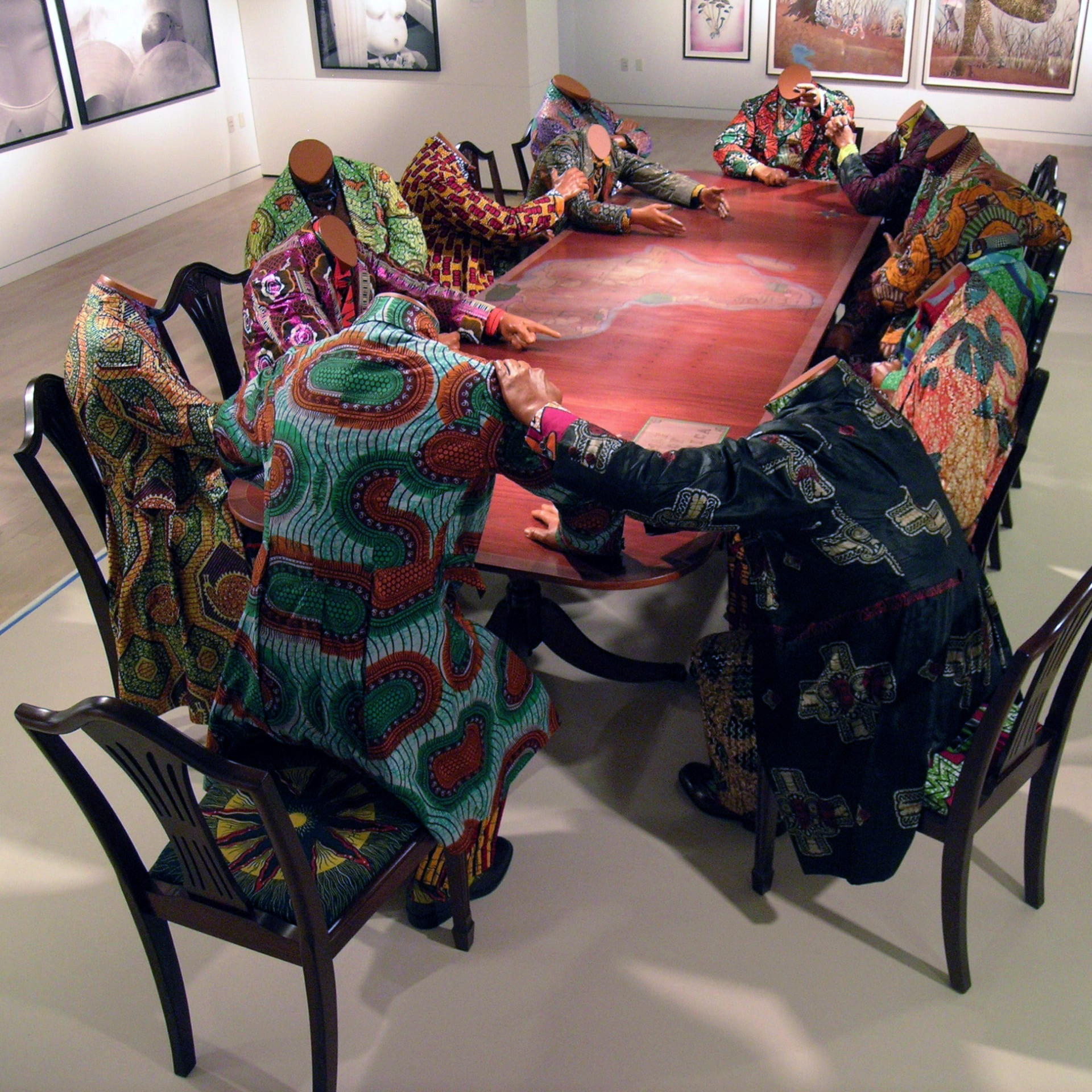 Yinka Shonibare MBE, Scramble for Africa, 2003, 14 life-size fiberglass mannequins, 14 chairs, table, Dutch wax printed cotton (The Pinnell Collection, Dallas)