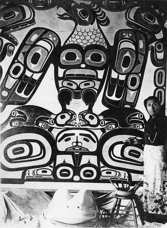 Silver Jim Jacobs (Tlingit), Yéilnaawú, Kichshaak, in front of his painting of the Gijook Xh’éen, Yakutat, Alaska, c. 1905.