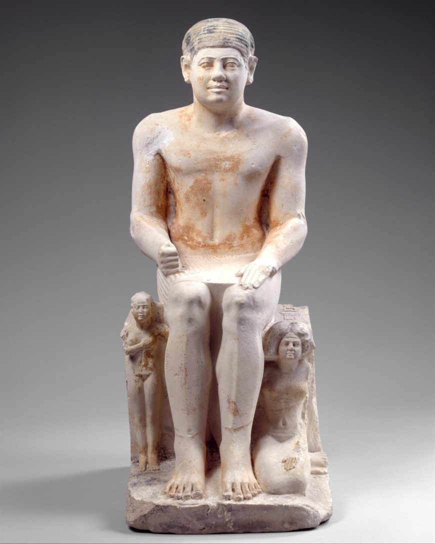 This statue represents the granary official Nikare with his family. His wife, Khuennub, kneels at his left and a daughter, Khuennebti stands at his right.