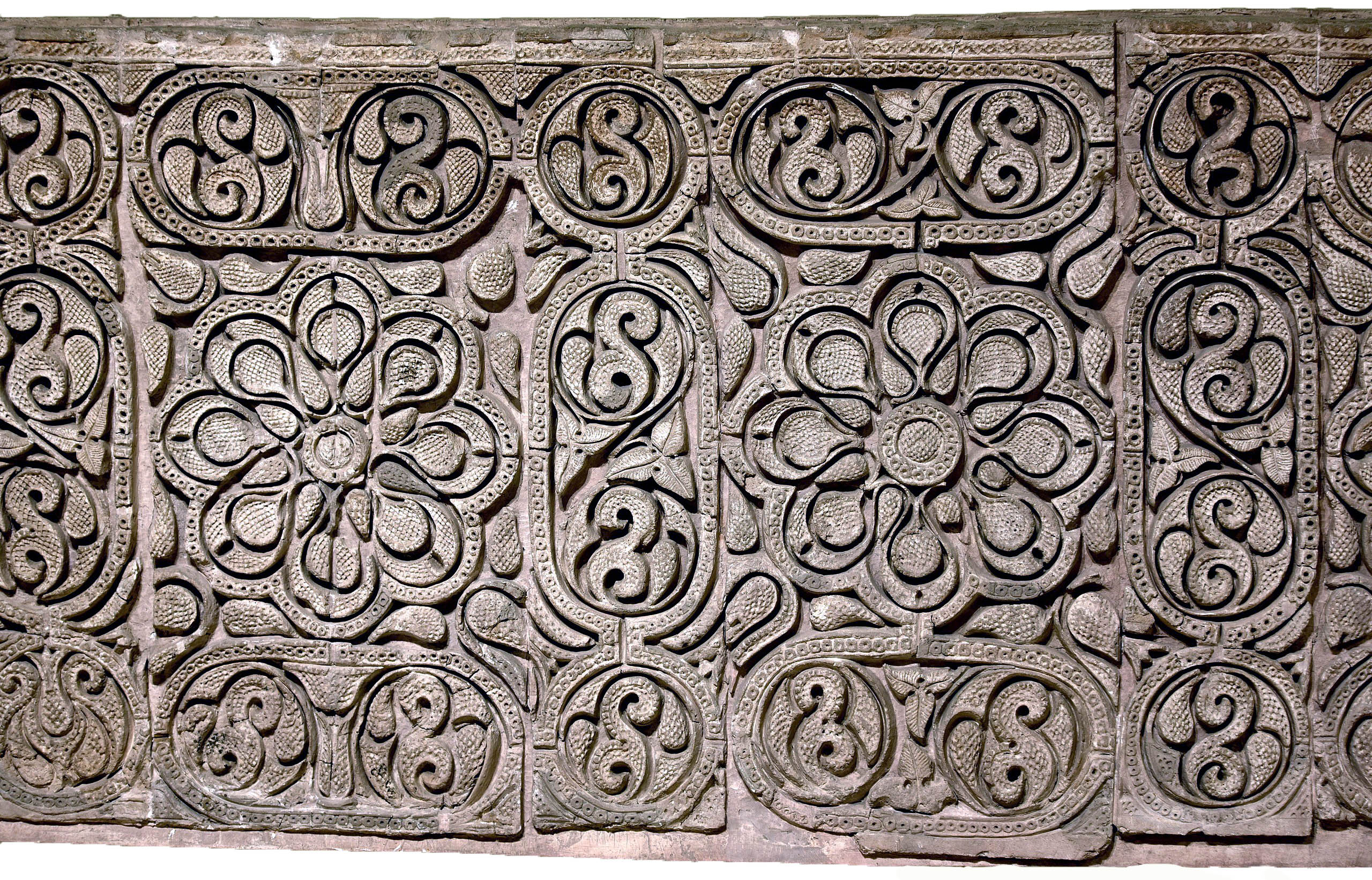 Carved stucco panel from the city of Samarra, Iraq. Floral pattern with geometric designs, grapes, vines, and ears of pine cones. 3rd century AH (9th century CE). On display at the Iraq Museum in Baghdad. (photo: Osama Shukir Muhammed Amin FRCP(Glasg), CC BY-SA 4.0)