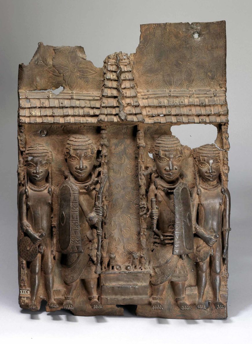 Artist Unidentified, Relief plaque showing four page figures in front of palace compound, courtyard or altar entrance with high tiled roof and turret, c. 16th–17th century, brass, from Benin City, Edo Kingdom, Nigeria, 55 x 39 cm (©Trustees of the British Museum)