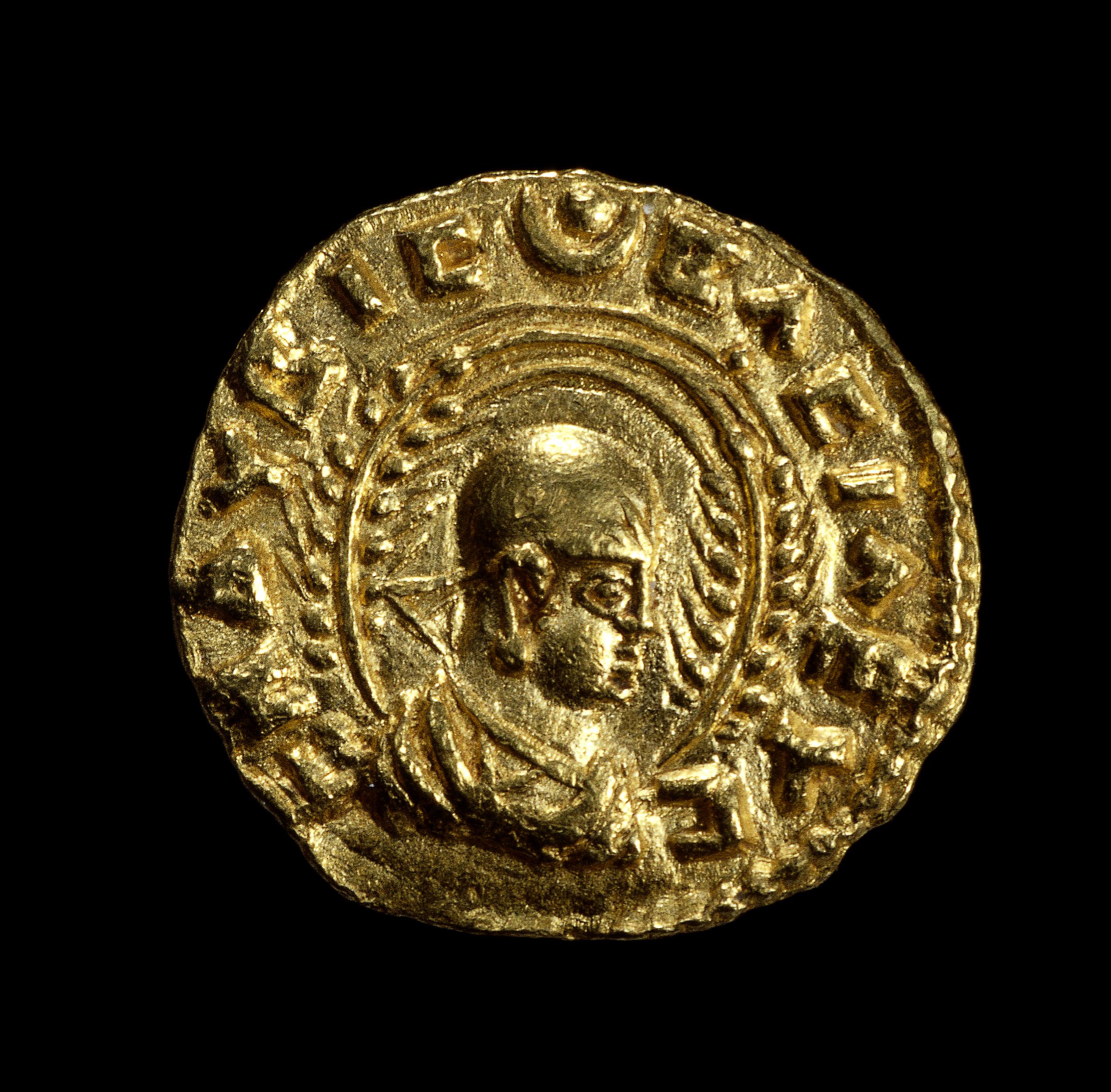 Obverse showing head and shoulders bust of King Endubis facing right, wearing headcloth with rays at forehead and triangular ribbon behind, framed by two wheat-stalks. Disc and crescent at top. Gold coin, c. 270–300 C.E., gold, minted in Aksum, modern Ethiopia (© Trustees of the British Museum)