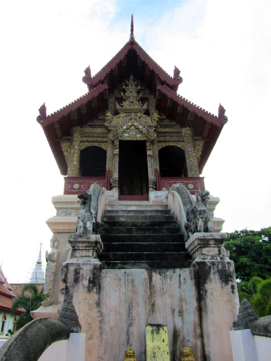 Ho Trai at Wat Phra Singh, Chiang Mai. The small, elaborately adorned wooden building is highly elevated on a masonry base (photo by the author).