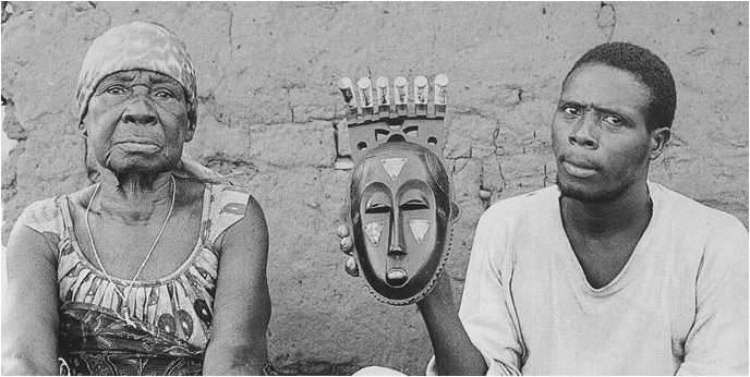 Moya Yanso and her stepson holding the portrait mask, 1971
