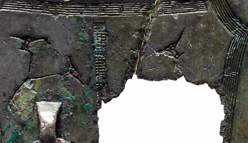 Reverse side of bronze object, with designs of a bird perched in a tree. Birds were considered to be sacred mediators that linked the heavens and earth, and brought peace and bounty to a village. Bronze Ritual Object with Farming Scenes, Early Iron Age, W. 12.8 cm, Treasure 1823 (National Museum of Korea)