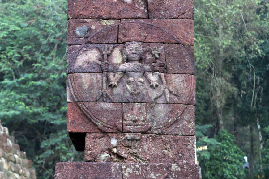The medallion in the southern platform, where the standing high crowned figure is seen holding double trisulas in both hands (photo: Panggah Ardiyansyah)