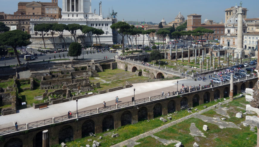 View of the Forum of Trajan, c. 112 C.E.. Later medieval walls can be seen amidst the grass on the left; the upright columns of the Basilica Ulpia can be seen on the right in front of the larger Column of Trajan (photo: Dr. Steven Zucker, CC BY-NC-SA 2.0)