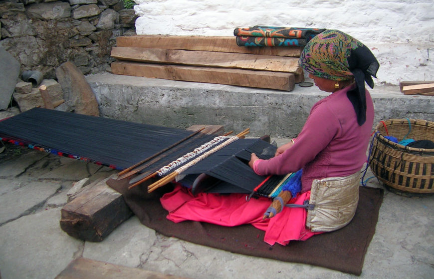 Weaver using a backstrap loom, Uttarakhand, India (photo: Shyamal L., CC BY-SA 3.0)