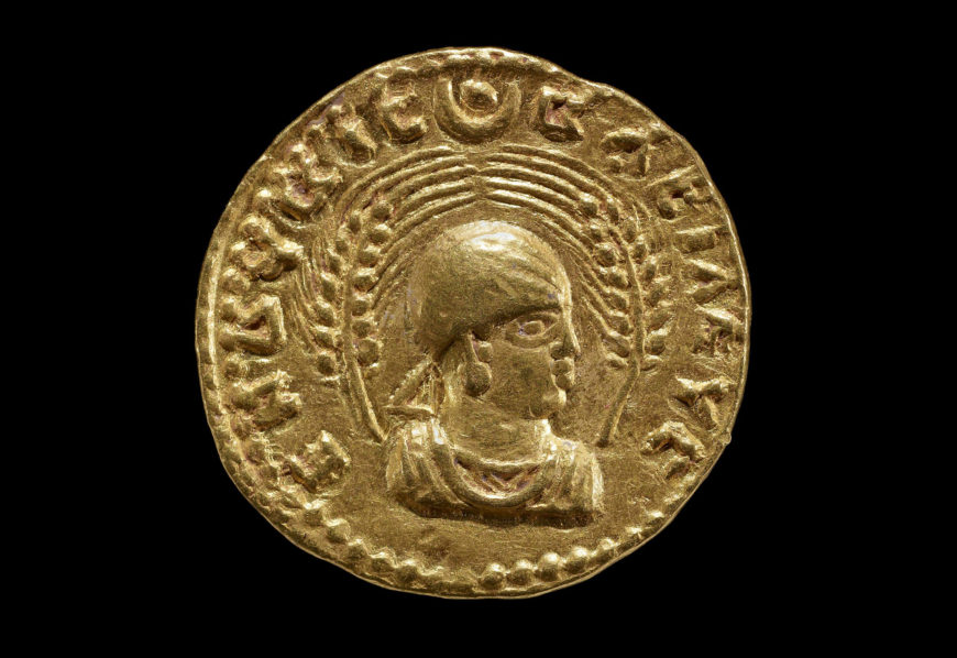  Obverse showing head and shoulders bust of King Endubis facing right, wearing headcloth with rays at forehead and triangular ribbon behind, framed by two wheat-stalks. Disc and crescent at top. Gold coin, c. 270–300 C.E., gold, Aksumite, modern Ethiopia (© Trustees of the British Museum)