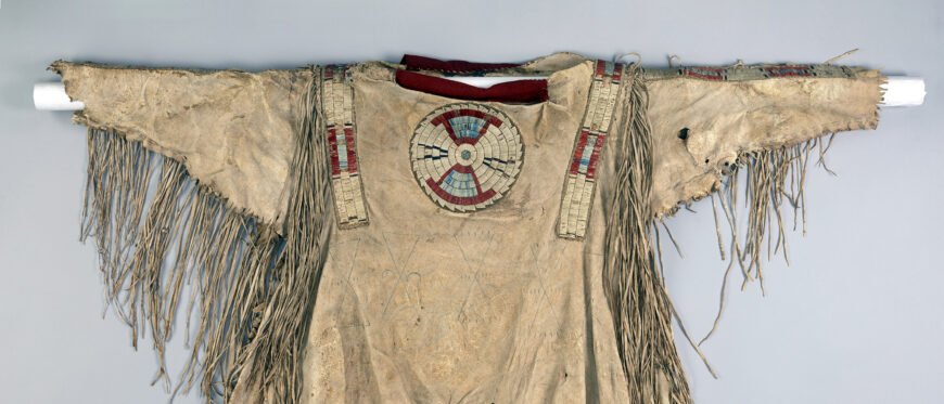 Quilled war shirt (back), c. 1800-1820. Native tanned hide, porcupine quills, red trade cloth, dyes, and sinew. 34 x 43 in. (Denver Art Museum)