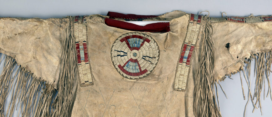 Quilled war shirt (front), c. 1800–1820. Native tanned hide, porcupine and possibly bird quills, plant material, red trade cloth, dyes, and sinew. 34 x 43 inches (Denver Art Museum)