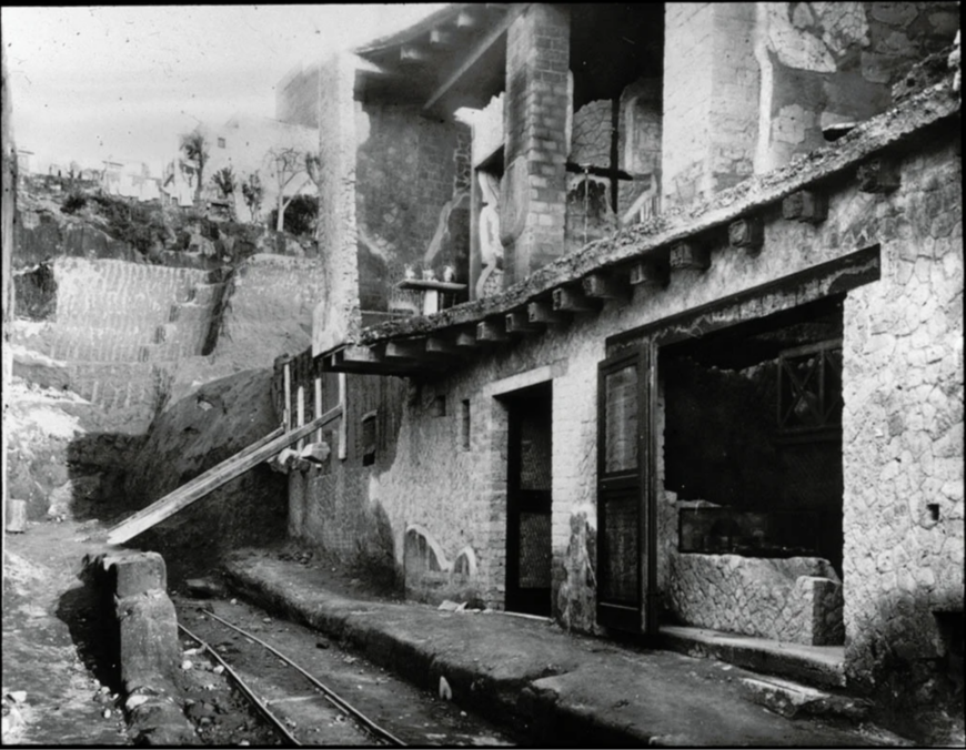 Fratelli Alinari, doorway to the House of Neptune and Amphitrite and wine/food shop counter at right during excavation, 1935 (Institute of Archaeology, University of Oxford)